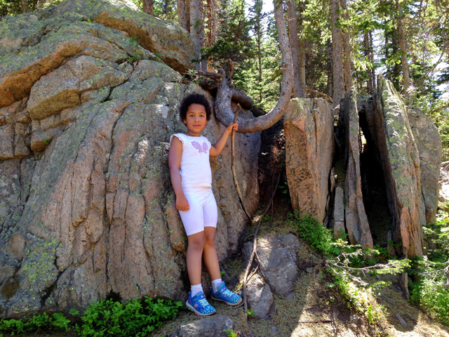 Irene with rocks and a bent tree trunk, State Forest State Park, Colorado, 2020