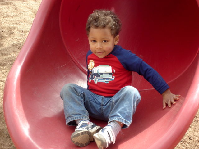 Joachim on a red slide at Rolland Moore Park, Fort Collins, Colorado, 2008